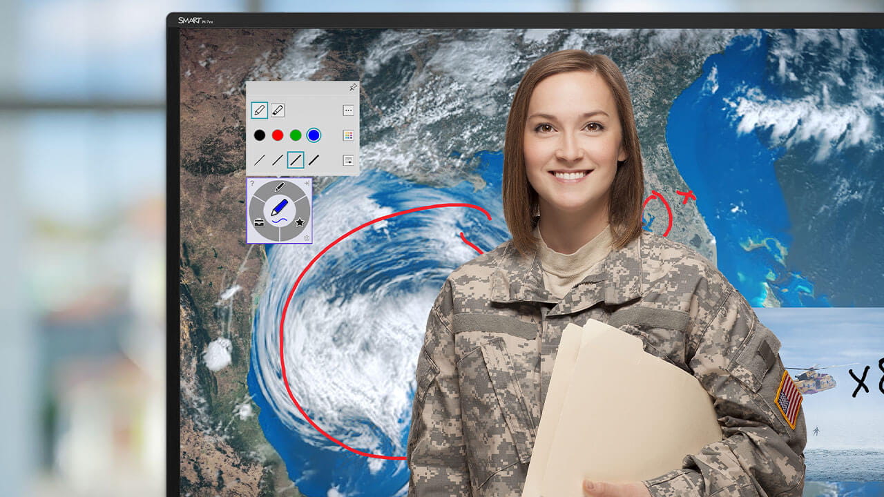 Military officer smiling while standing in front of a SMART Board displaying a weather system, with annotations and tools visible.