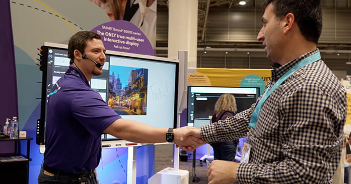Photo of a SMART team member engaging in a handshake with a businessman.