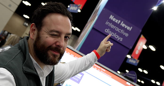 Photo of a SMART representative pointing at event signage.