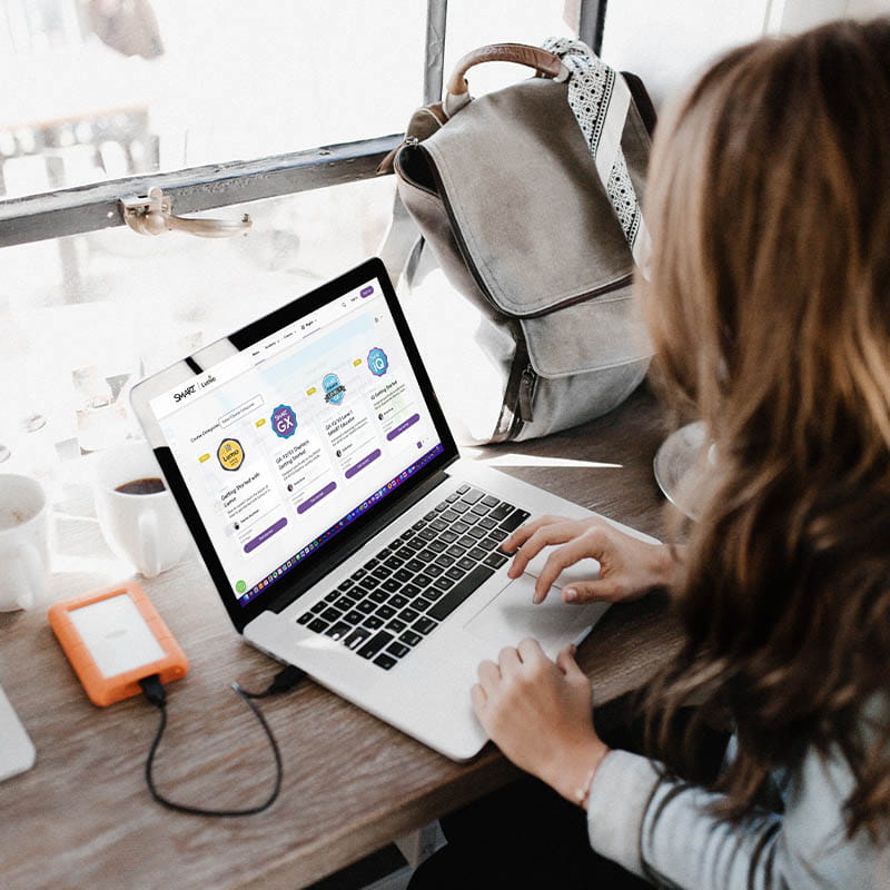 Woman working on a laptop with SMART Lumio lesson plans and resources on the screen, ideal for remote teaching or content creation.